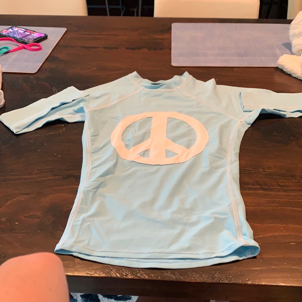 Blue petite girls rash guard with peace sign.